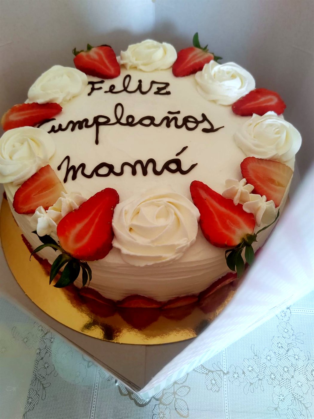 Tarta blanca con rosetones de crema, fresas y letras de chocolate: Feliz cumpleaños mamá
