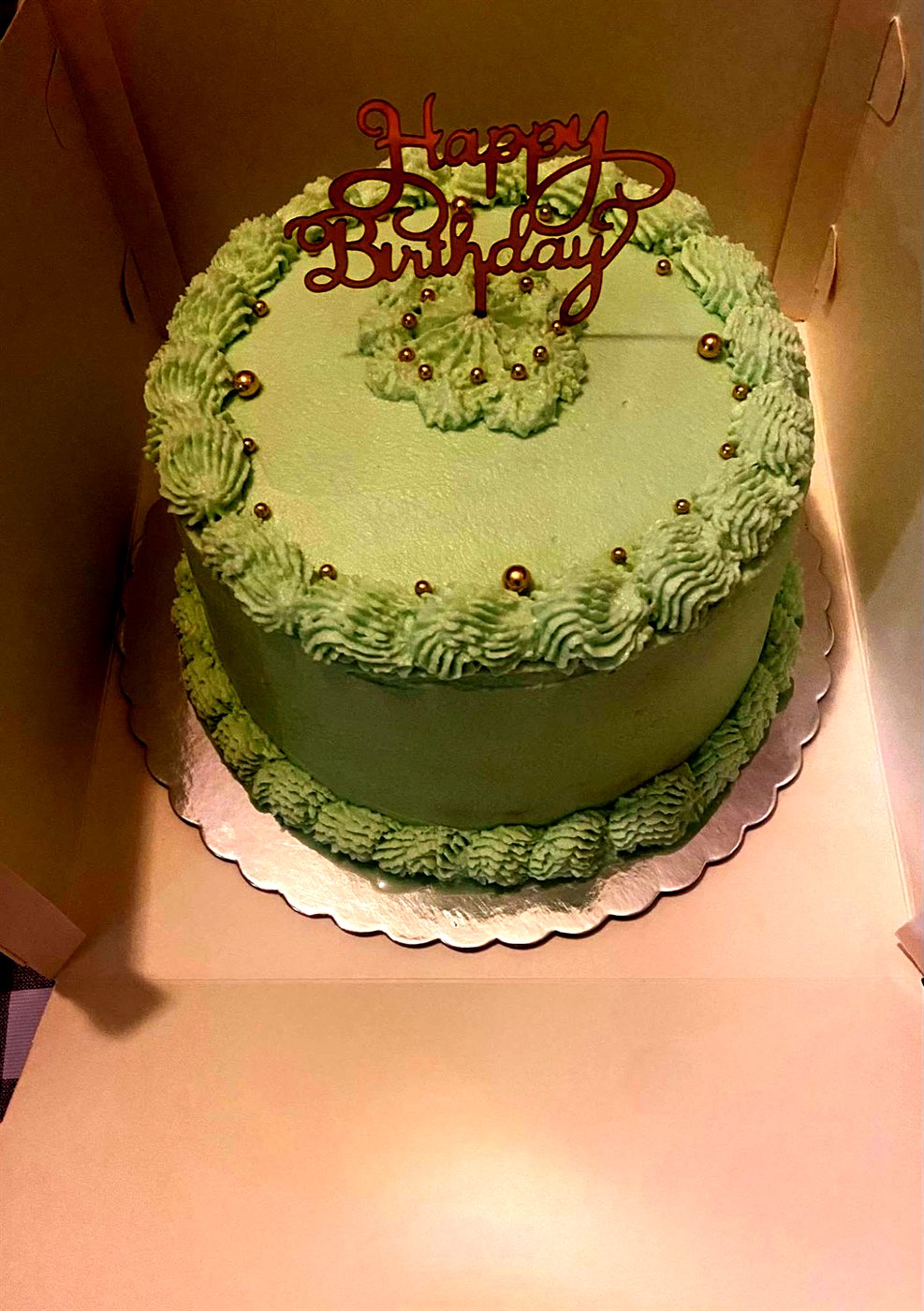 Tarta de cumpleaños verde menta con perlas doradas y cartel Happy Birthday